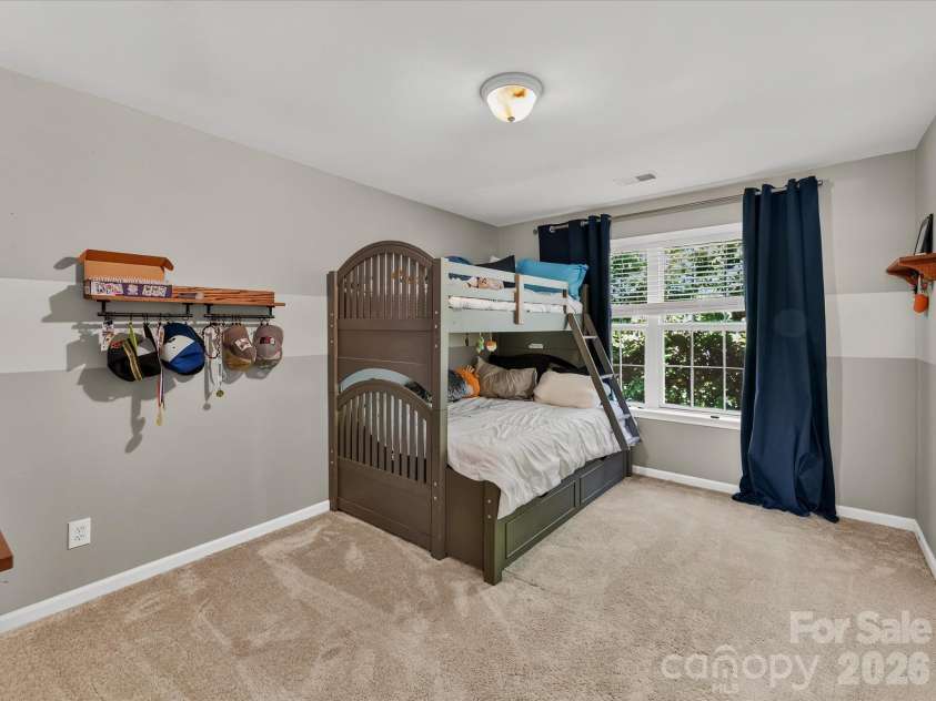 150 Cavendish Drive, Mooresville, NC 28115.  MLS# CAR4416863, YatesRealty ID 47420. Spacious secondary bedroom featuring soft carpeting, a large window with natural light, and plenty of room for flexible furniture arrangements.