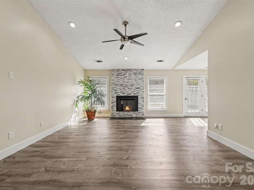 10117 Crayton Drive, Charlotte, NC 28269.  MLS# CAR4415978, YatesRealty ID 47431. Spacious living room with vaulted ceiling and fireplace.