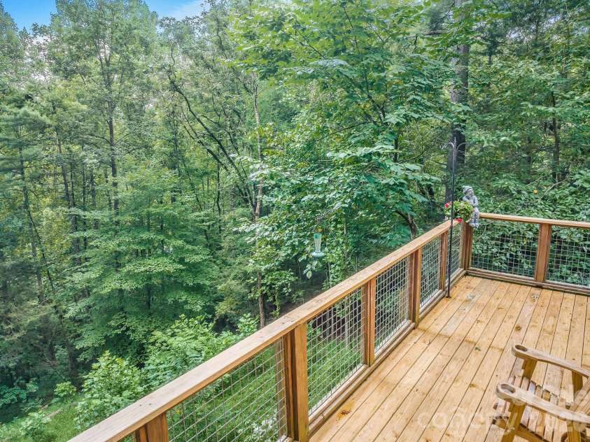 553 River Bend Drive, Mars Hill, NC 28754.  MLS# CAR4418089, YatesRealty ID 47487. Main floor deck with fire place opens up to mature forest.