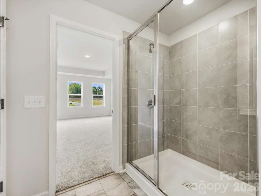6609 Fire Lily Lane, Charlotte, NC 28216.  MLS# CAR4419428, YatesRealty ID 47646. Owner's Bathroom Shower Leading Back into the Owner's Suite