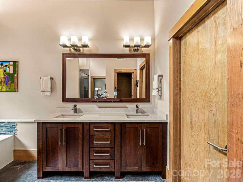 33 Robinson Creek Road, Asheville, NC 28803.  MLS# CAR4415737, YatesRealty ID 47672. Double vanity, custom mirror, with access to two spacious walk-in closets.