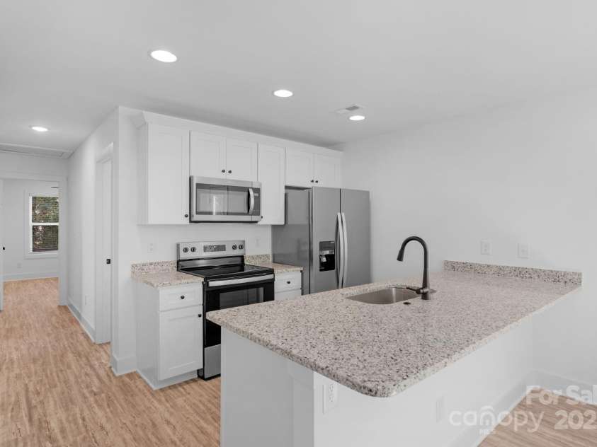 324 Ashford Street, Chester, SC 29706.  MLS# CAR4319489, YatesRealty ID 4768. Bright open kitchen with modern shaker cabinets, granite counters, and bar seating perfect for entertaining.