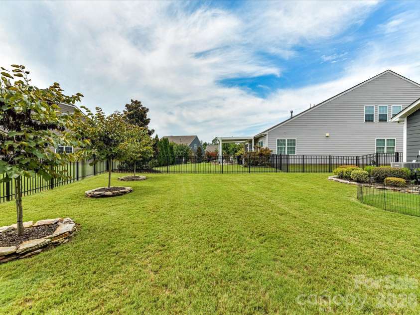 9005 Cape Breton Lane, Lancaster, SC 29720.  MLS# CAR4416986, YatesRealty ID 47740. Back yard and Stone Edging at Tree Beds