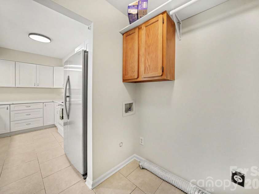 11009 Carmel Crossing Road, Charlotte, NC 28226.  MLS# CAR4408434, YatesRealty ID 47823. Laundry room with storage.  A barn door or folding doors can separate it from kitchen
