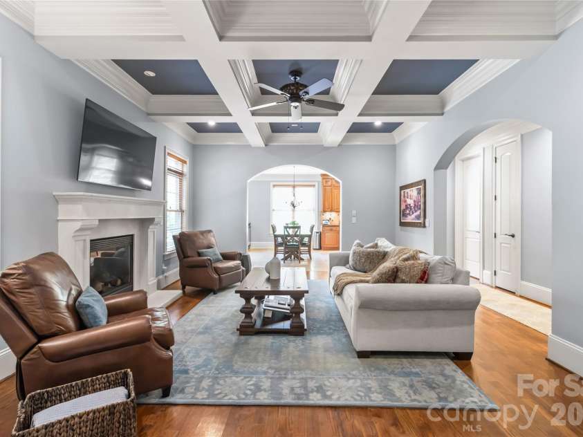 7320 Summerlin Place, Charlotte, NC 28226.  MLS# CAR4418024, YatesRealty ID 47825. A custom stone fireplace, rich coffered ceilings, and dramatic arched entryways serve as the centerpieces of this inviting family room.