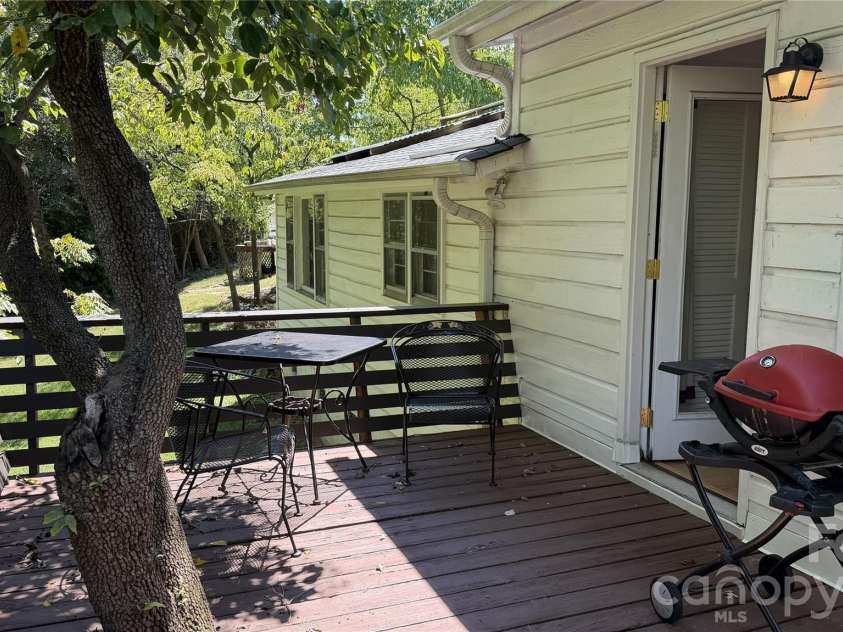 209 Auten Circle, Mount Holly, NC 28120.  MLS# CAR4414320, YatesRealty ID 47945. Back deck where previous owner built deck around a dogwood tree for shade