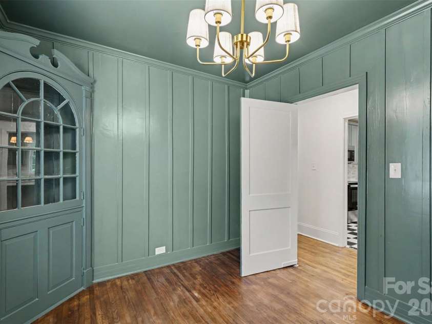 601 Marion Sims Drive, Lancaster, SC 29720.  MLS# CAR4404710, YatesRealty ID 48048. Sunlit dining room or flex space featuring soft ash green walls, custom built-in glass cabinetry, classic French doors, and serene views of the surrounding yard.