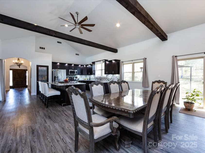 7545 Brancy Street, Kannapolis, NC 28081.  MLS# CAR4242395, YatesRealty ID 4813. Dining Room boasts Open floor plan and is full of natural light! Vinyl plank flooring, exposed beams, vaulted ceiling with ceiling fans and recessed lighting. Multiple large windows and sliding glass doors provide a bea