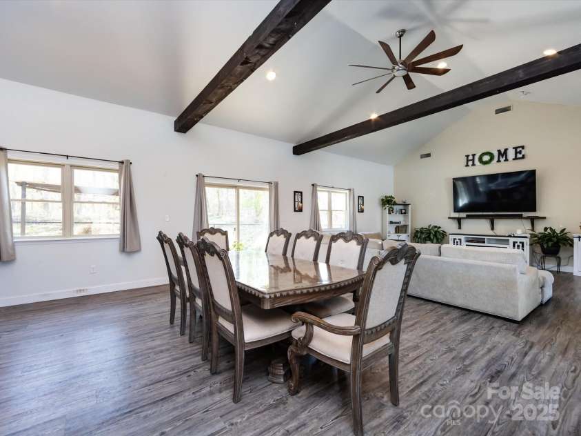 7545 Brancy Street, Kannapolis, NC 28081.  MLS# CAR4242395, YatesRealty ID 4813. Dining Room boasts Open floor plan and is full of natural light! Vinyl plank flooring, exposed beams, vaulted ceiling with ceiling fans and recessed lighting. Multiple large windows and sliding glass doors provide a bea