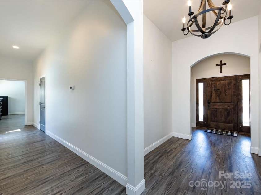 7545 Brancy Street, Kannapolis, NC 28081.  MLS# CAR4242395, YatesRealty ID 4813. Gorgeous Foyer and hallway featuring a Wood Door with decorative metalwork , sidelight windows providing tons of natural light, screen door, chandelier, recessed lighting and  vinyl plank flooring !