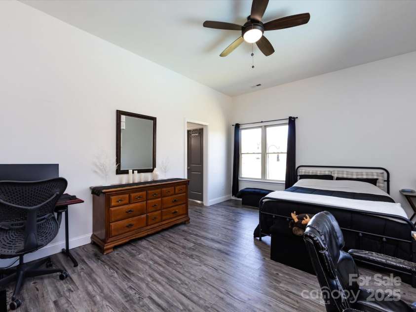 7545 Brancy Street, Kannapolis, NC 28081.  MLS# CAR4242395, YatesRealty ID 4813. Large 4th Bedroom features a private bathroom, walk in closet, vinyl plank flooring, ceiling fan/light.