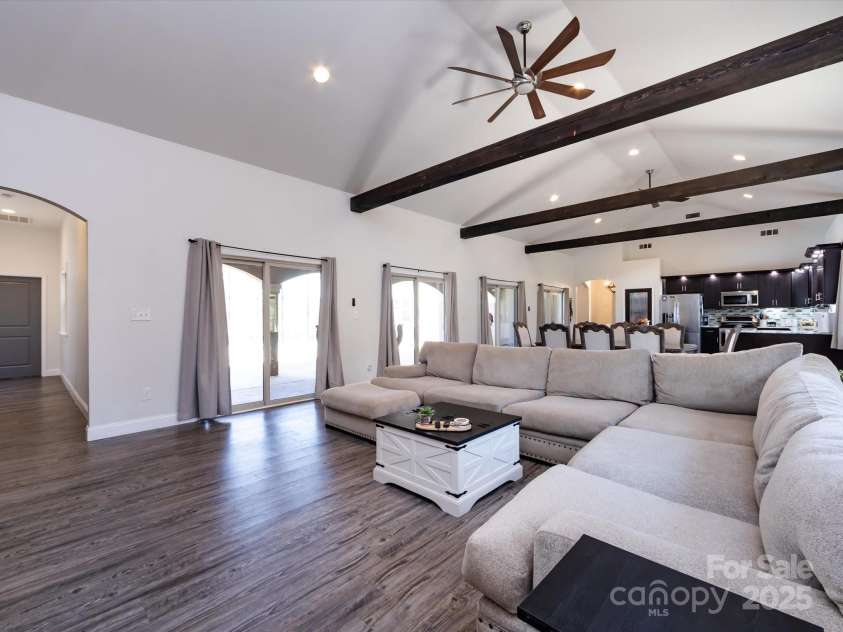 7545 Brancy Street, Kannapolis, NC 28081.  MLS# CAR4242395, YatesRealty ID 4813. Living Room is full of natural light! Vinyl plank flooring, exposed beams, vaulted ceiling with ceiling fans and recessed lighting. Multiple large windows and sliding glass doors provide a beautiful view and easy access