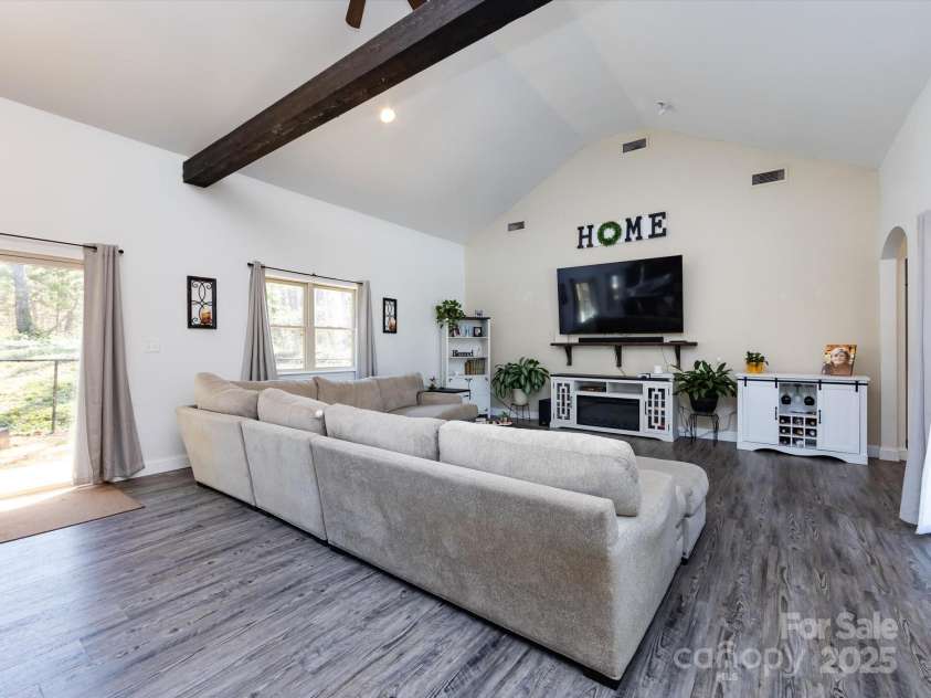 7545 Brancy Street, Kannapolis, NC 28081.  MLS# CAR4242395, YatesRealty ID 4813. Living Room is full of natural light! Vinyl Plank flooring, exposed beams, vaulted ceiling with ceiling fans and recessed lighting. Multiple large windows and sliding glass doors provide a beautiful view and easy access