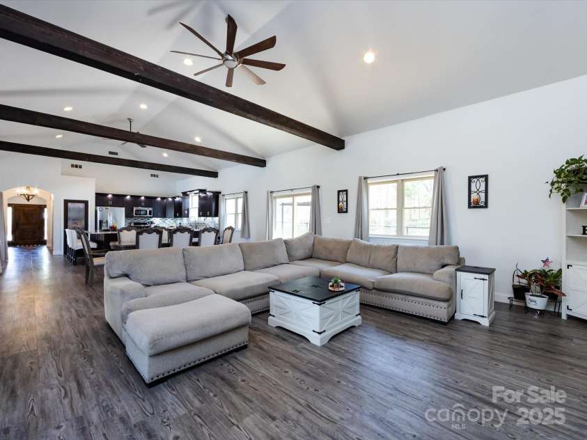 7545 Brancy Street, Kannapolis, NC 28081.  MLS# CAR4242395, YatesRealty ID 4813. Living Room is full of natural light! Vinyl plank flooring, exposed beams, vaulted ceiling with ceiling fans and recessed lighting. Multiple large windows and sliding glass doors provide a beautiful view and easy access