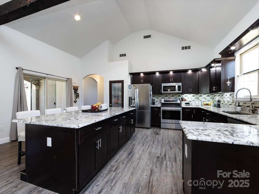 7545 Brancy Street, Kannapolis, NC 28081.  MLS# CAR4242395, YatesRealty ID 4813. Stunning Kitchen boasting an open floor plan , walk in pantry, exotic granite countertops, huge breakfast bar, tiled backsplash, stainless steel appliances, large sink and tons of cabinets with accent lighting. The Kitc
