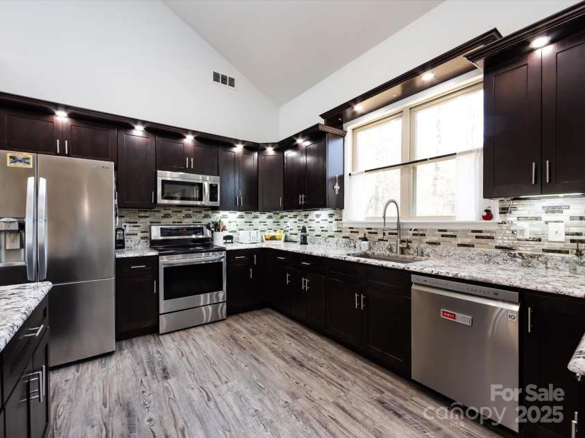 7545 Brancy Street, Kannapolis, NC 28081.  MLS# CAR4242395, YatesRealty ID 4813. Stunning Kitchen boasting an open floor plan , walk in pantry, exotic granite countertops, huge breakfast bar, tiled backsplash, stainless steel appliances, large sink and tons of cabinets with accent lighting. The kitc