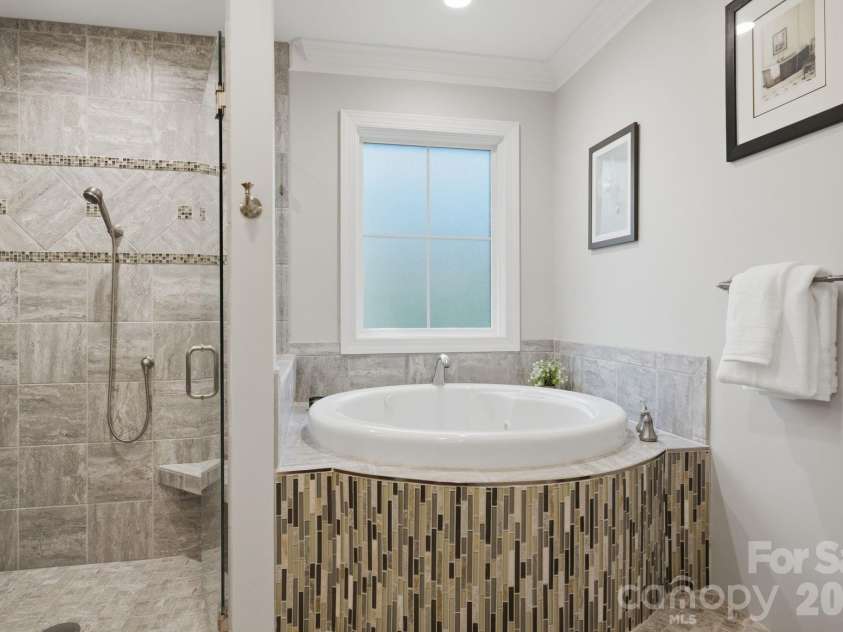 7197 Windy Ridge Drive, Iron Station, NC 28080.  MLS# CAR4417271, YatesRealty ID 48262. Garden tub with modern tile surround