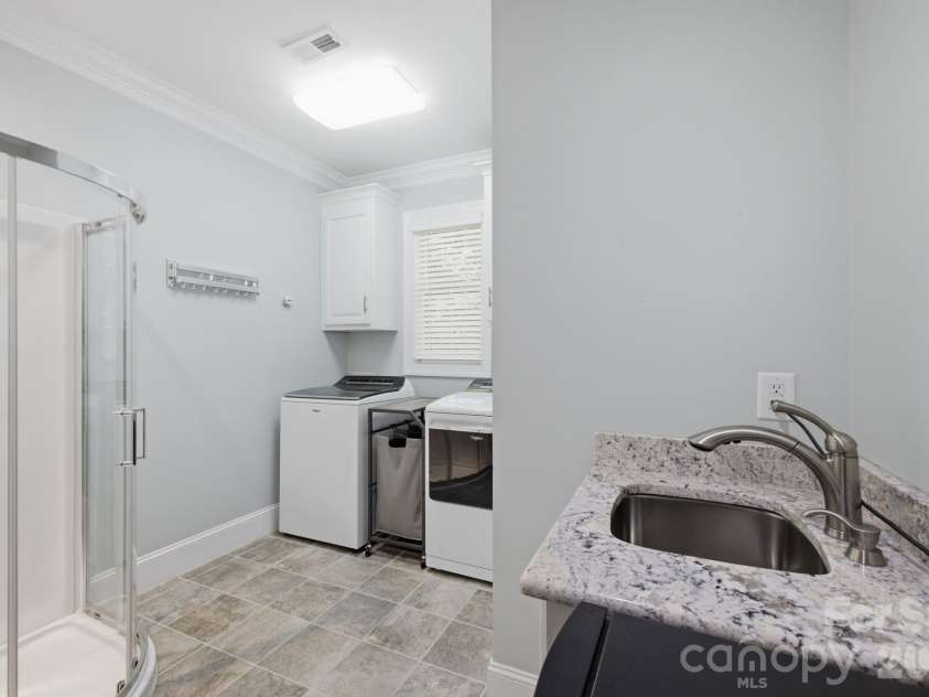 7197 Windy Ridge Drive, Iron Station, NC 28080.  MLS# CAR4417271, YatesRealty ID 48262. Large laundry room with sink and shower which is perfect for bathing the pets!