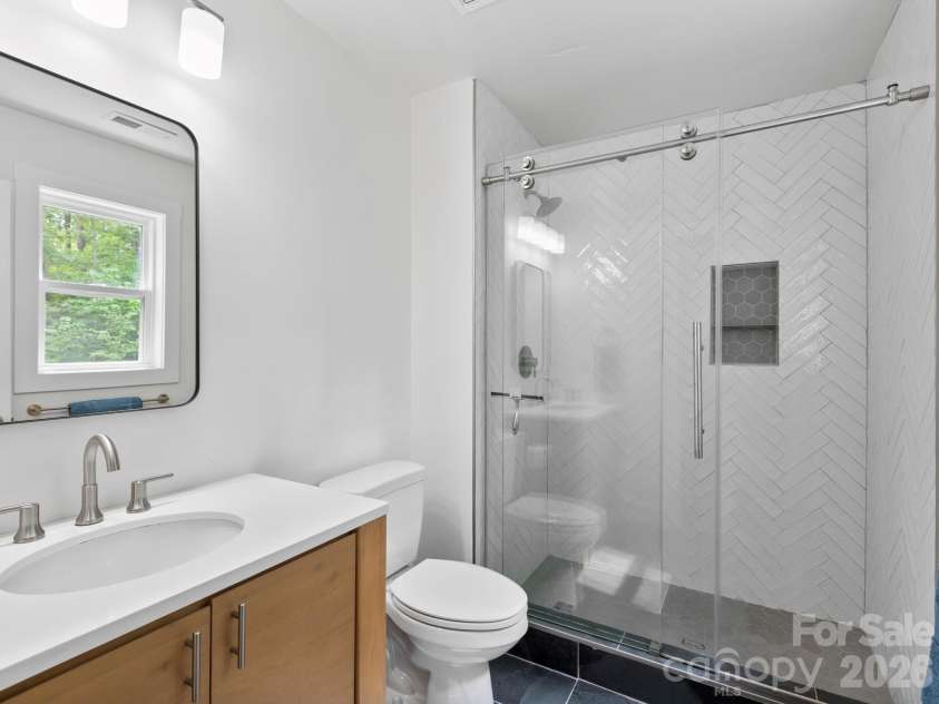 41 Bear Trail, Fairview, NC 28730.  MLS# CAR4420605, YatesRealty ID 48293. Fully tiled shower + contemporary finishes in primary en suite.