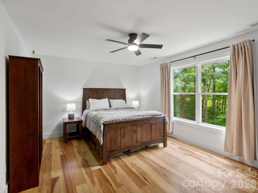 41 Bear Trail, Fairview, NC 28730.  MLS# CAR4420605, YatesRealty ID 48293. Primary bedroom with windows facing southwest, catching warm sunset light.
