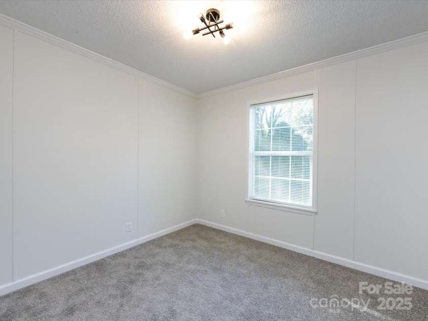907 4th Avenue, Gastonia, NC 28054.  MLS# CAR4306590, YatesRealty ID 4842. Bedroom view with new carpet, farmhouse hardware, light fixture