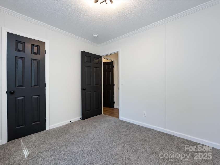 907 4th Avenue, Gastonia, NC 28054.  MLS# CAR4306590, YatesRealty ID 4842. Bedroom view with new carpet, farmhouse hardware, light fixture
