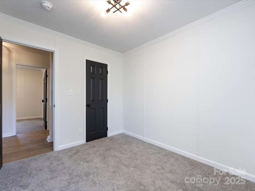 907 4th Avenue, Gastonia, NC 28054.  MLS# CAR4306590, YatesRealty ID 4842. Bedroom view with new carpet, farmhouse hardware, light fixture