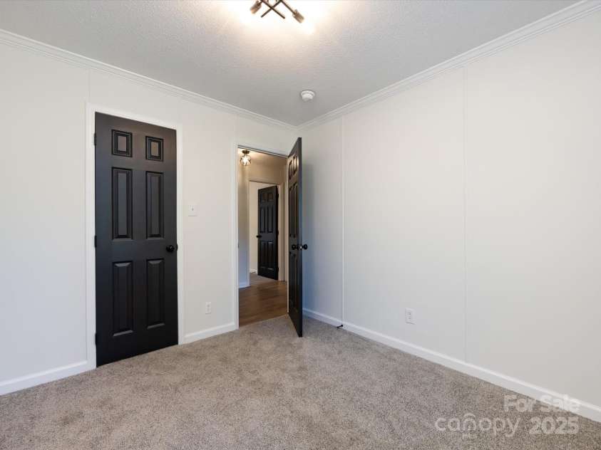 907 4th Avenue, Gastonia, NC 28054.  MLS# CAR4306590, YatesRealty ID 4842. Bedroom view with new carpet, farmhouse hardware, light fixture