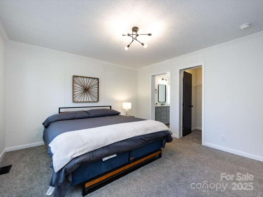 907 4th Avenue, Gastonia, NC 28054.  MLS# CAR4306590, YatesRealty ID 4842. View of primary bedroom with new carpet & light fixture.