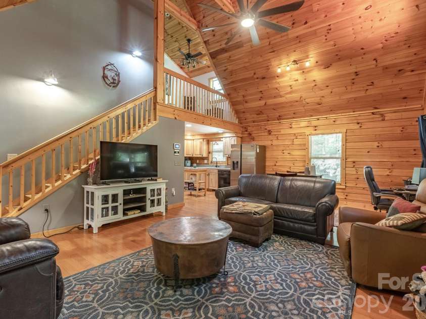 257 Adirondack Trail, Nebo, NC 28761.  MLS# CAR4418359, YatesRealty ID 48489. Living room looking into kitchen, and loft above.