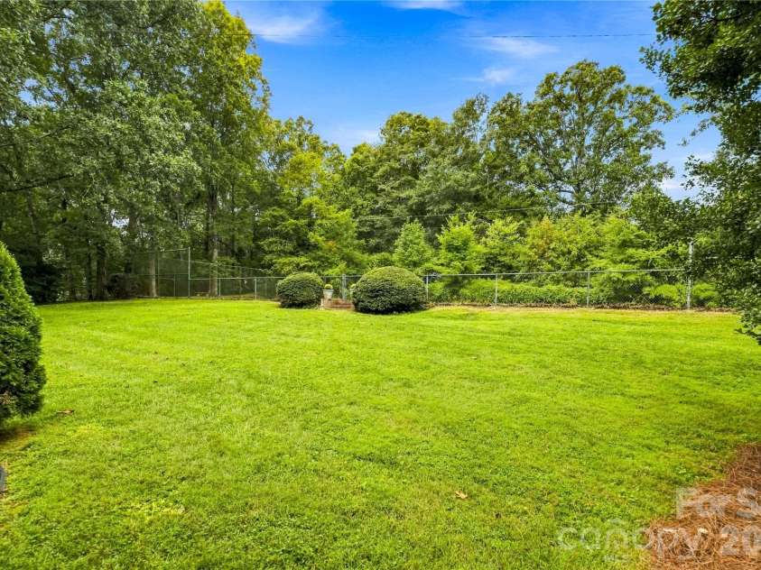 209 Labans Lane, Lincolnton, NC 28092.  MLS# CAR4419321, YatesRealty ID 48497. Open lawn surrounded by mature trees and greenery.