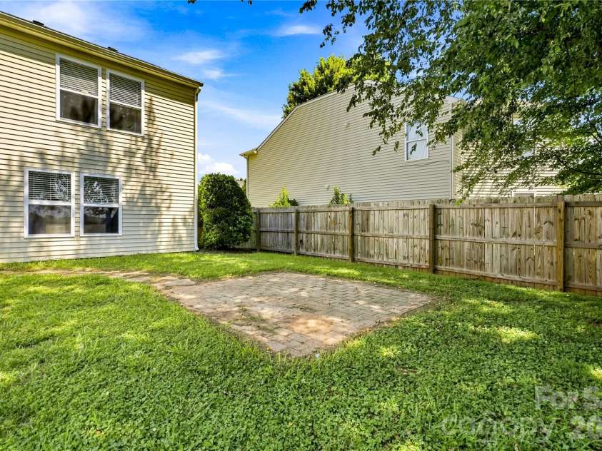 117 Farm Springs Drive, Mount Holly, NC 28120.  MLS# CAR4417237, YatesRealty ID 48501. Brick patio inside the fully fenced backyard