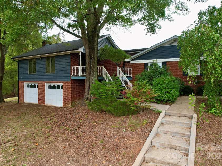 11720 Kluttz Road, Gold Hill, NC 28071.  MLS# CAR4310441, YatesRealty ID 4865. Side load 3 door garage with workshop, wood burning stove, and built in cabinets/shelving