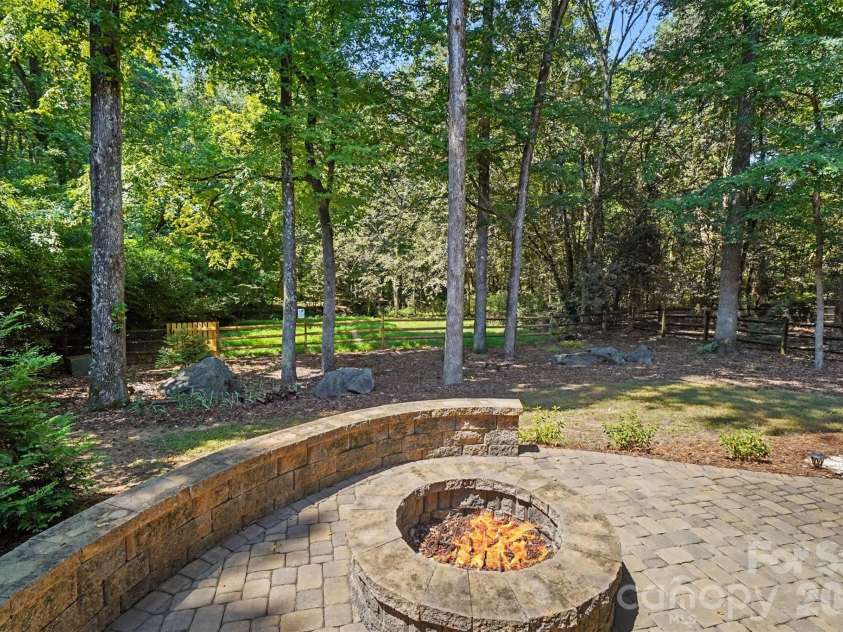 6443 High Creek Court, Charlotte, NC 28277.  MLS# CAR4420225, YatesRealty ID 48657. Backyard fire pit surrounded by trees
