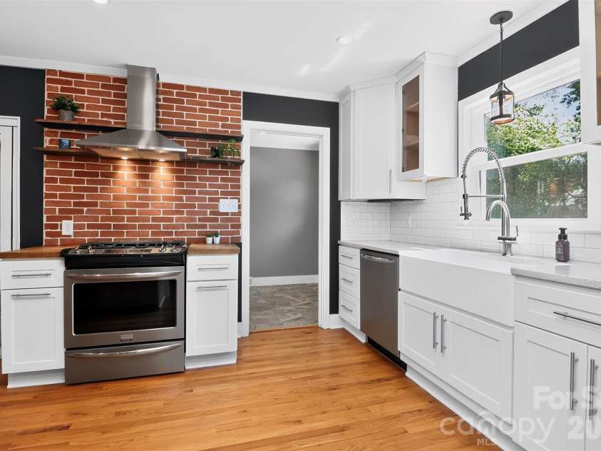 831 Faircrest Drive, Charlotte, NC 28210.  MLS# CAR4421440, YatesRealty ID 48734. Updated kitchen features gas range with exposed brick and stainless steel appliances