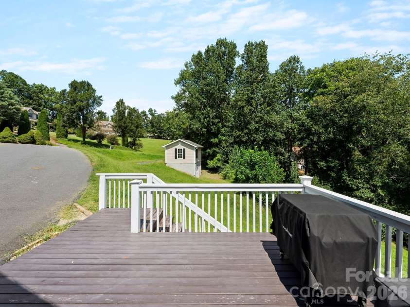 66 Azalea Drive, Weaverville, NC 28787.  MLS# CAR4421280, YatesRealty ID 48881. Side deck/patio beside garage looking towards detached workshop.