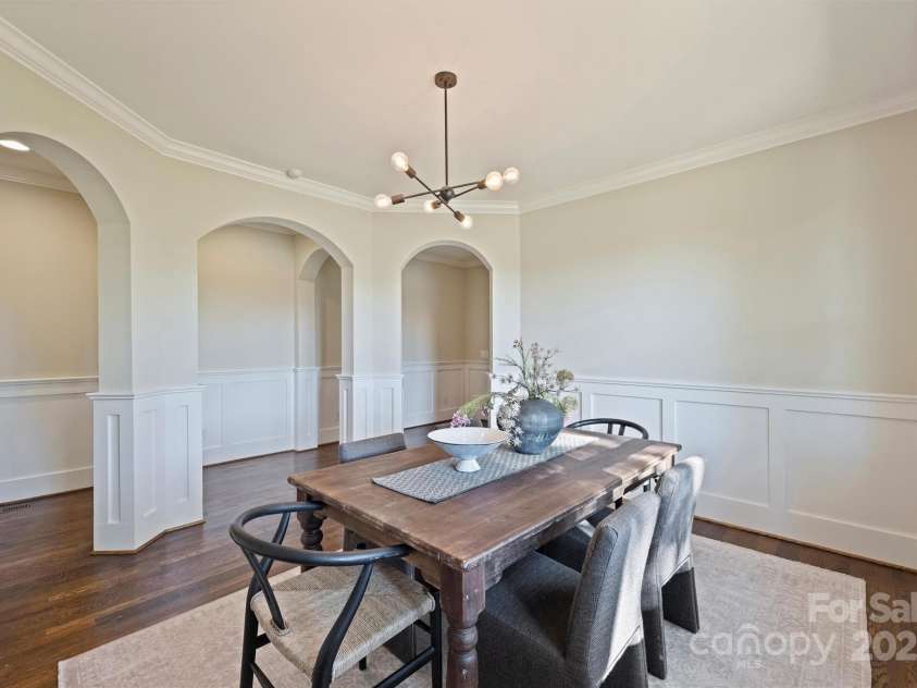 3304 Josephine Court, Charlotte, NC 28205.  MLS# CAR4319912, YatesRealty ID 48912. Elegant Dining Room with arched openings, crown and chair rail moldings, wainscoting, and modern chandelier.