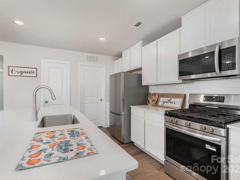 150 Mountain Bridge Way, Statesville, NC 28625.  MLS# CAR4330213, YatesRealty ID 4896. Kitchen with stainless steel appliances, gas range, large island, tile backsplash, walk in pantry, and more