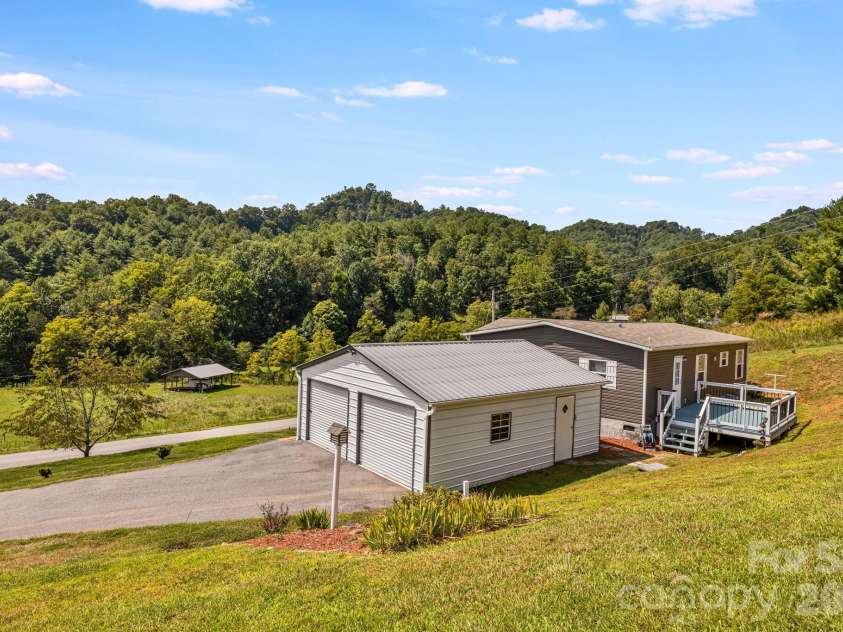 582 John Henry Road, Burnsville, NC 28714.  MLS# CAR4421454, YatesRealty ID 49014. Garage and surrounding mountain setting