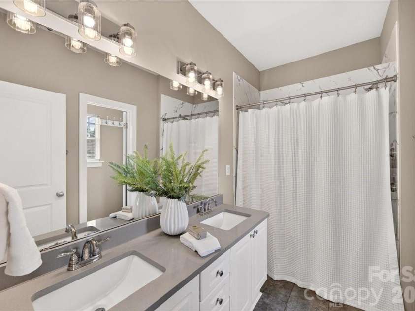9026 Crusaders Court, Matthews, NC 28105.  MLS# CAR4420940, YatesRealty ID 49102. Primary bath with new tiled shower, lighting, and tiled floor!