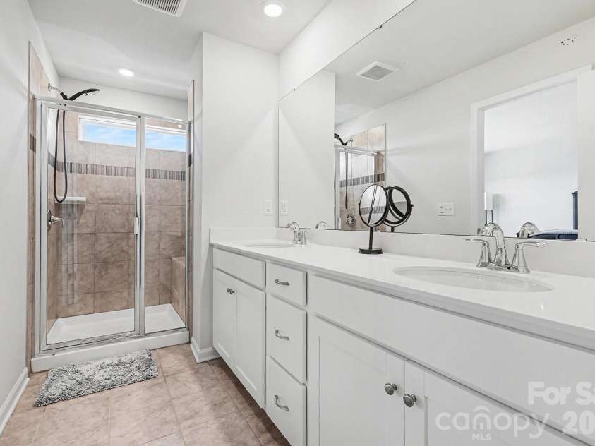 117 Morning Gap Parkway, Fort Mill, SC 29715.  MLS# CAR4333429, YatesRealty ID 4918. Primary bathroom with double sinks and walk in shower with tile bench.