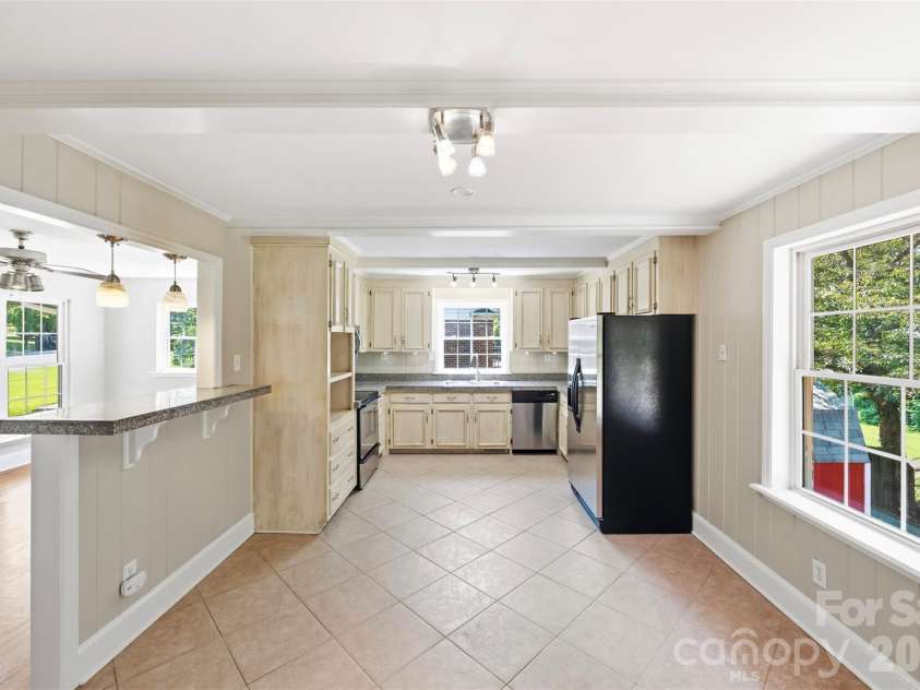 6506 Candlewood Drive, Charlotte, NC 28210.  MLS# CAR4401762, YatesRealty ID 49207. Kitchen and dinning spaces flow nicely and can easily accommodate table chairs bar stools etc.. Nice view looking out back and down to the lush green space in the fenced back yard