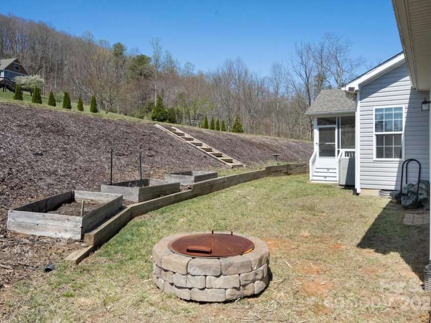 52 Stone Ridge Trail, Mills River, NC 28759.  MLS# CAR4239861, YatesRealty ID 4935. Fire pit & garden beds in back yard
