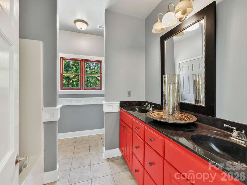 9821 Harvest Lane, Davidson, NC 28036.  MLS# CAR4422485, YatesRealty ID 49465. Full bath features tile flooring, generous vanity space, and classic architectural trim details.