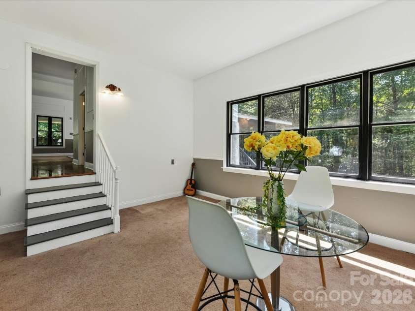 9821 Harvest Lane, Davidson, NC 28036.  MLS# CAR4422485, YatesRealty ID 49465. Versatile sunroom or flex space offers abundant natural light, panoramic wooded views, and endless possibilities for dining, office, or additional living space.