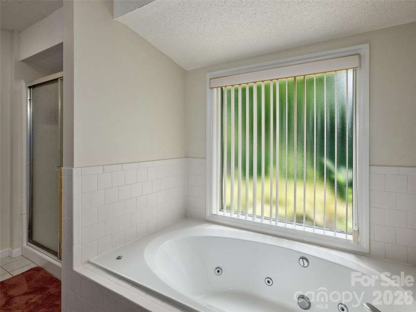 5 St Andrews Drive, Etowah, NC 28729.  MLS# CAR4419907, YatesRealty ID 49514. Primary bath includes a spacious tub and natural light from the adjoining window
