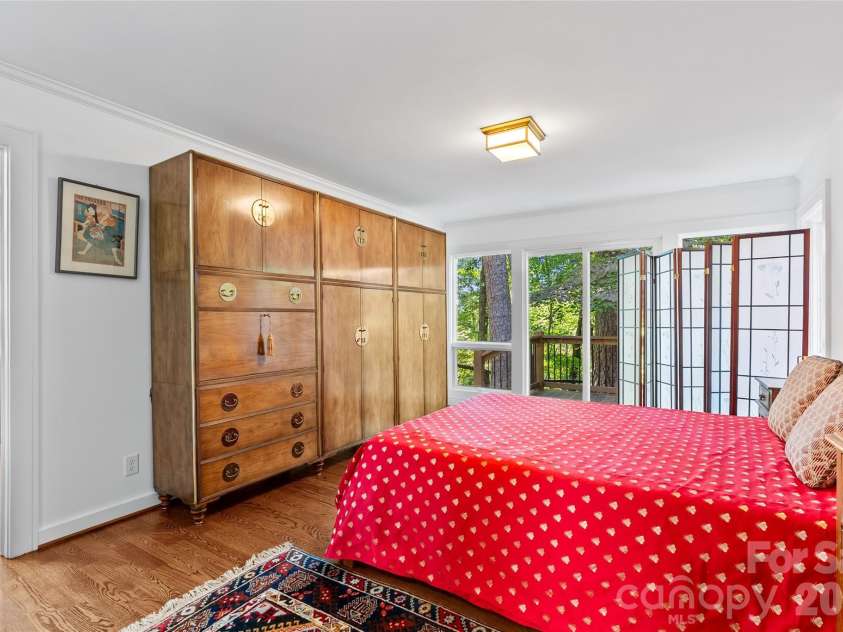 566 Canebrake Road, Tryon, NC 28782.  MLS# CAR4299420, YatesRealty ID 4954. Main level primary bedroom opens out to a new deck.