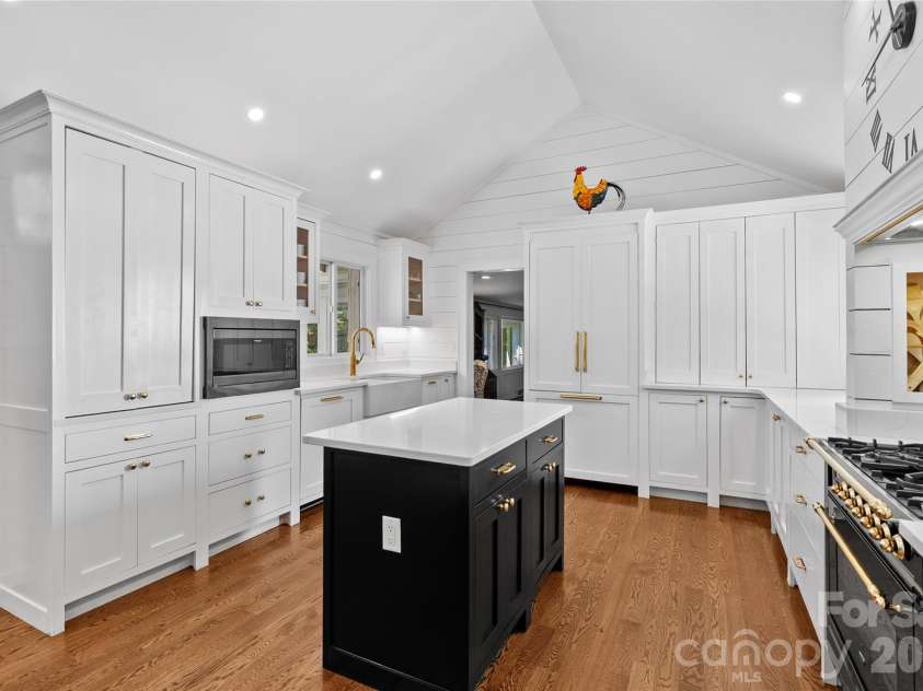 566 Canebrake Road, Tryon, NC 28782.  MLS# CAR4299420, YatesRealty ID 4954. Refrigerator, dishwasher have custom panels. Two work sinks and an island complete the space.