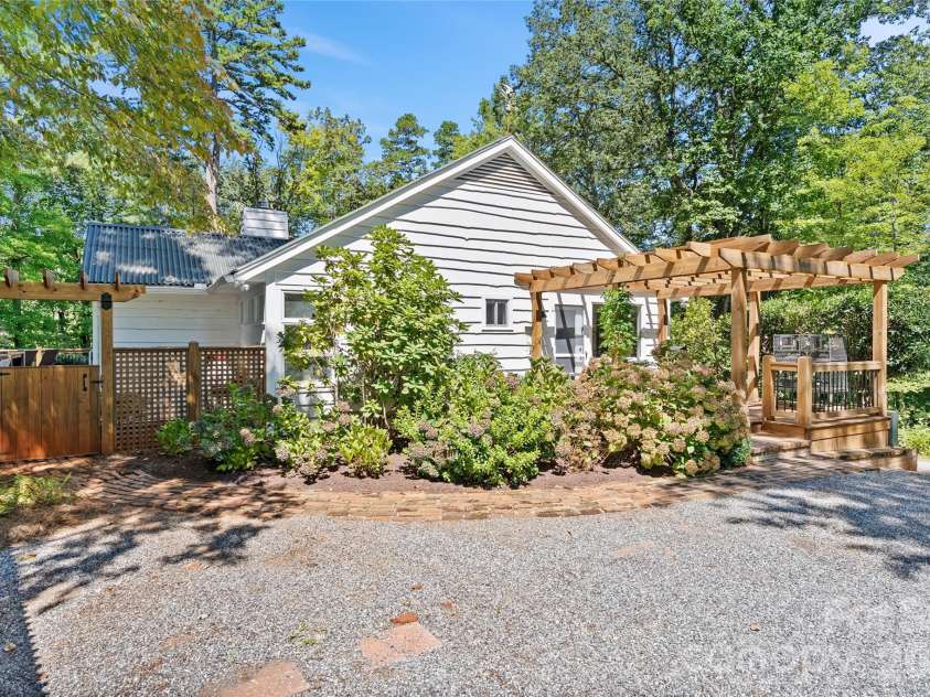 566 Canebrake Road, Tryon, NC 28782.  MLS# CAR4299420, YatesRealty ID 4954. Separate side entrance to the home with a carport and extensive parking for guests. This door leads to the large great room with cathedral ceilings.