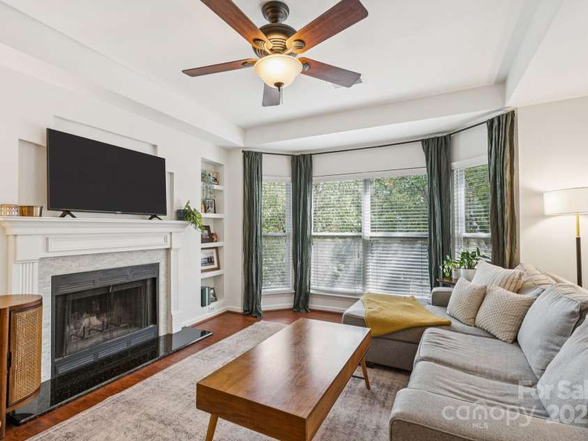 509 Graham Street, Charlotte, NC 28202.  MLS# CAR4292760, YatesRealty ID 4960. Bright, open living room with beautiful bay windows, tray ceiling, and a cozy, wood-burning fireplace.